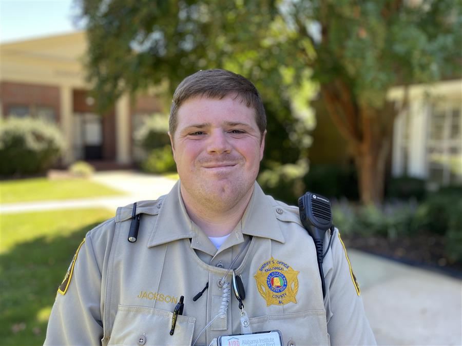 Officer Jackson smiles to camera while in uniform.